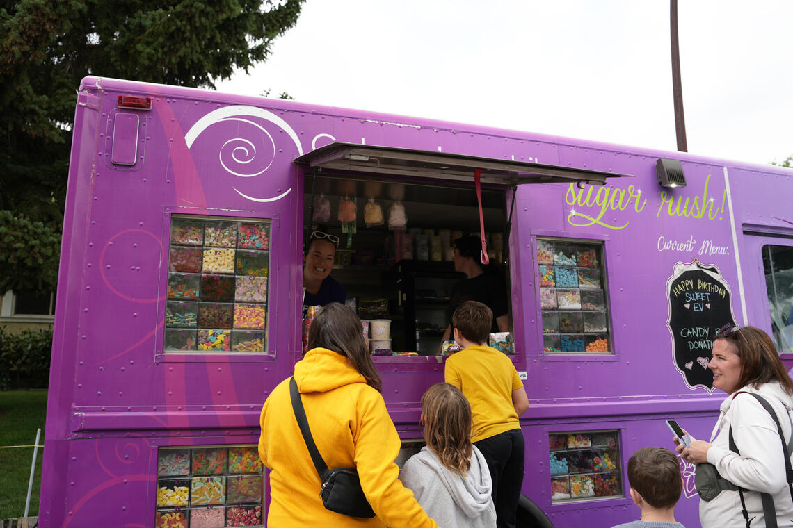 Alyssa Tilston in her purple candy truck greeting customers.