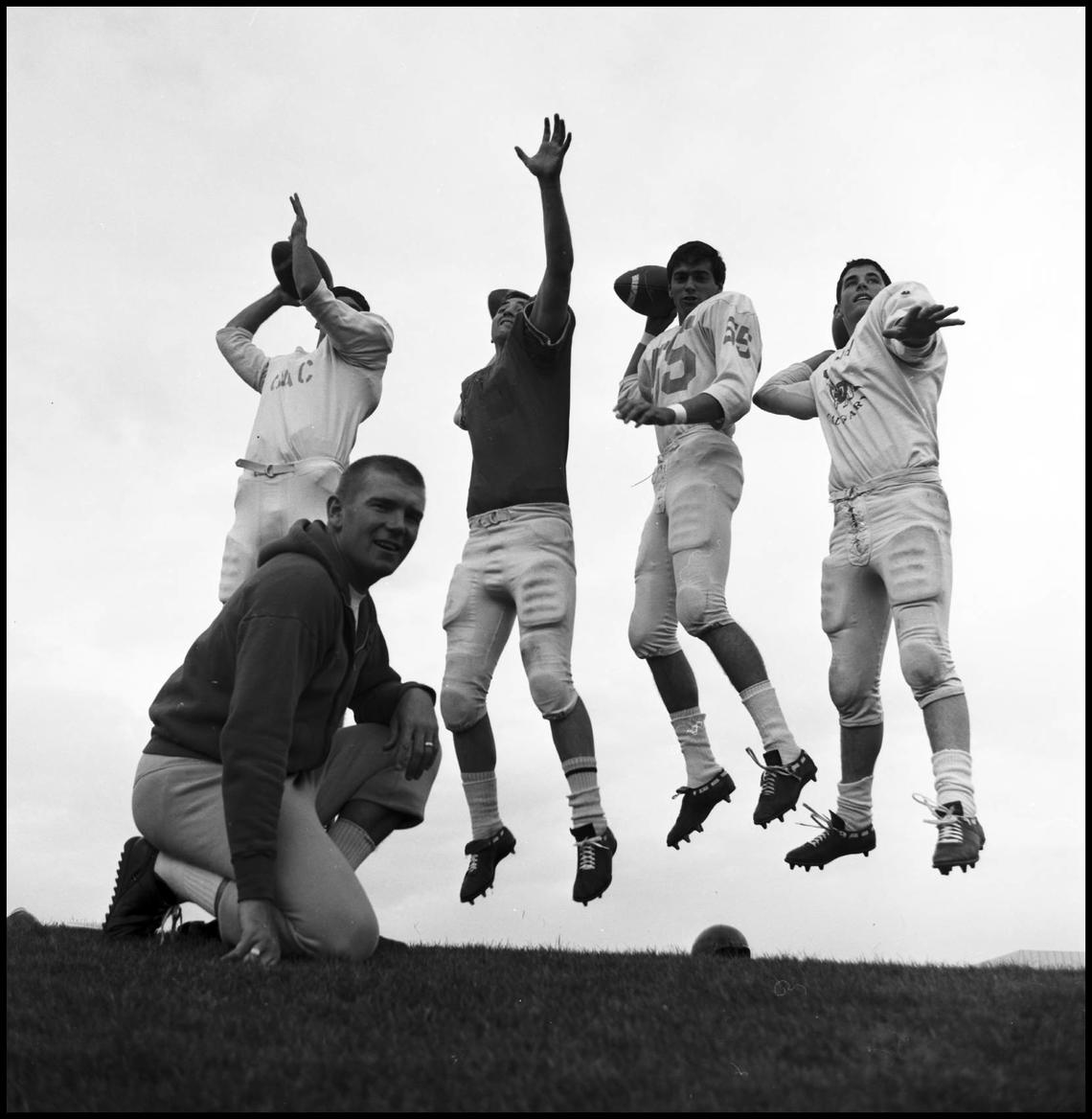 Dennis Kadatz, University of Calgary Dinosaurs football head coach in 1967, evaluates four quarterback hopefuls. From left: George Edwards, Jim Christie, Lorne Prokopy and Mike Christie. 