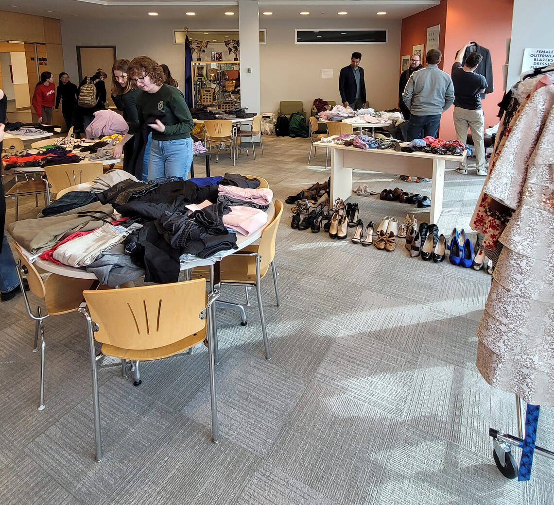 Clothing is arranged on tables throughout a room