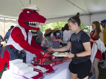 Rex hands out Wagon Wheels to community members during the President's Stampede BBQ on July 12. 