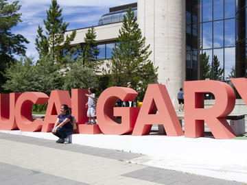 Family members of a UCalgary staff member pose with the UCalgary letters during  the President's Stampede BBQ on July 12. 