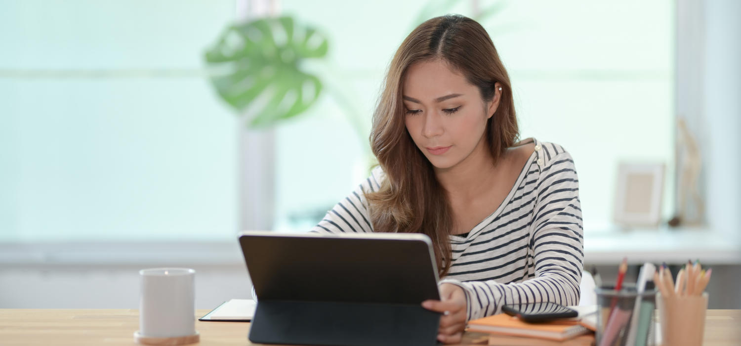 Woman in striped shirt using a tablet device.