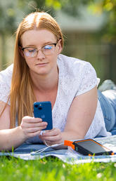 student laying on grass