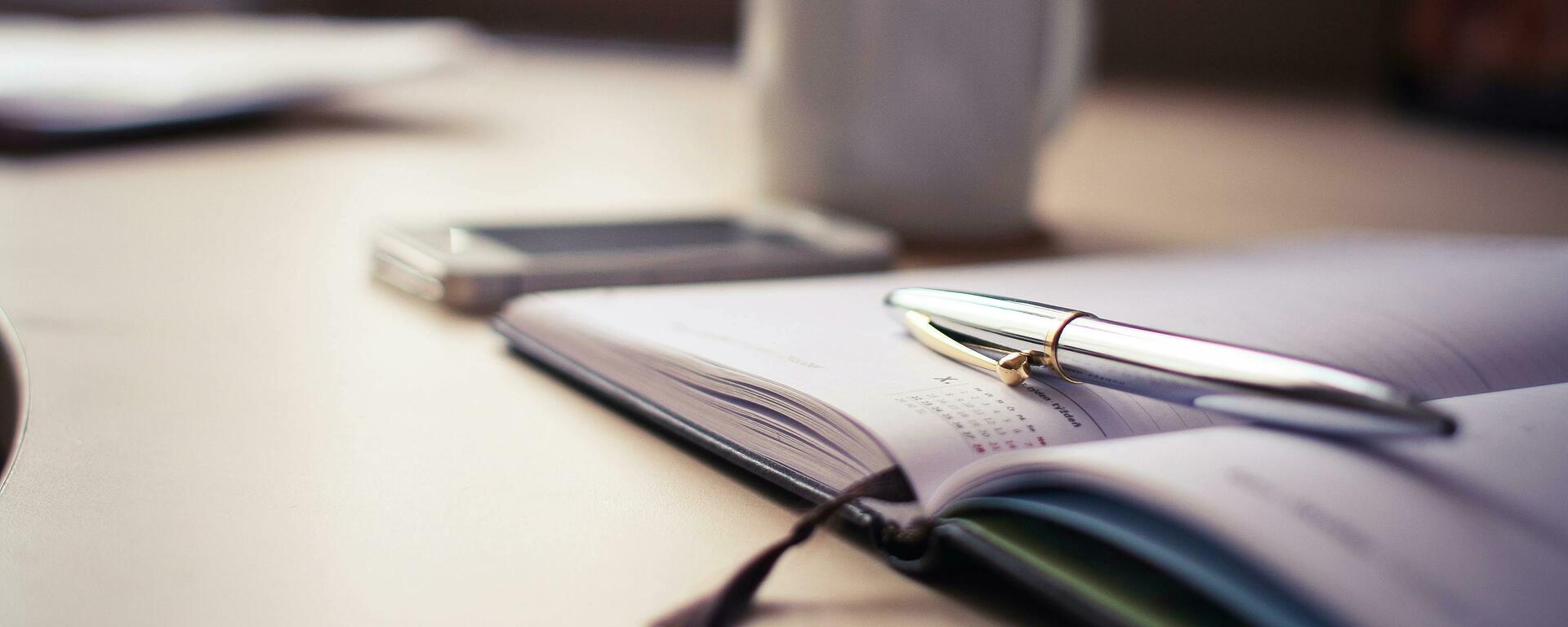 Metal pen laying atop a day planner
