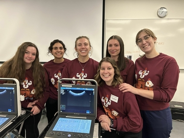 Group photo of 6 veterinary student SVECCS club executives with a portable ultrasound machine