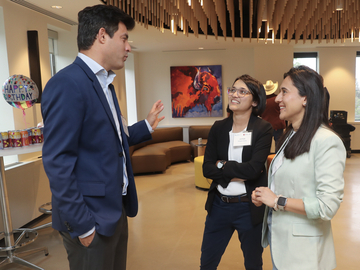 Three people standing & talking