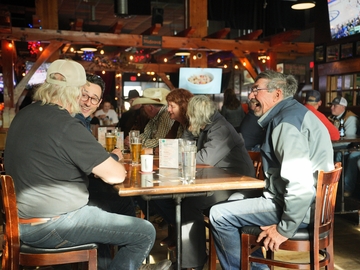 A table of men enjoying themselves at a restaurant